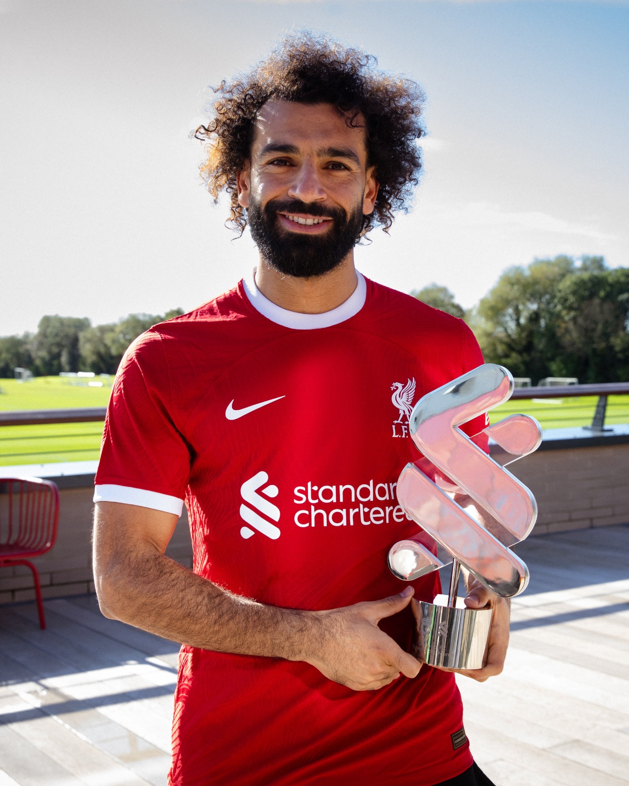 Mo Salah holding the Standard Chartered Player of the Month award.