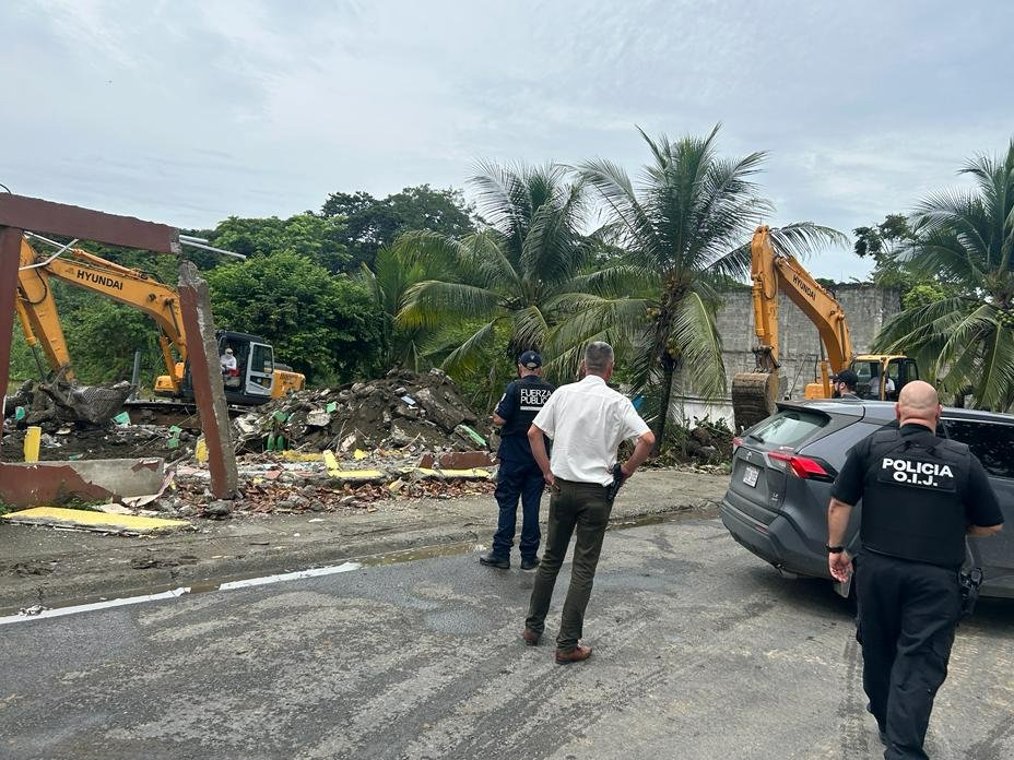 FiscaliaCR's tweet photo. Limón: #FiscalíaCR y #OIJ derriban cinco estructuras construidas en terrenos del Estado que eran usados por presuntos narcotraficantes, en Moín. 
Se investiga el delito de usurpación de bienes de dominio público. https://t.co/2rY90pyUbU