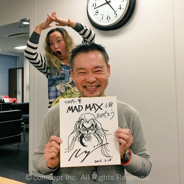 Keiji Inafune in 2016 showing off his sketch of Immortan Joe at Comcept HQ. 

A Rush plushie can be seen on the desk in the background. 