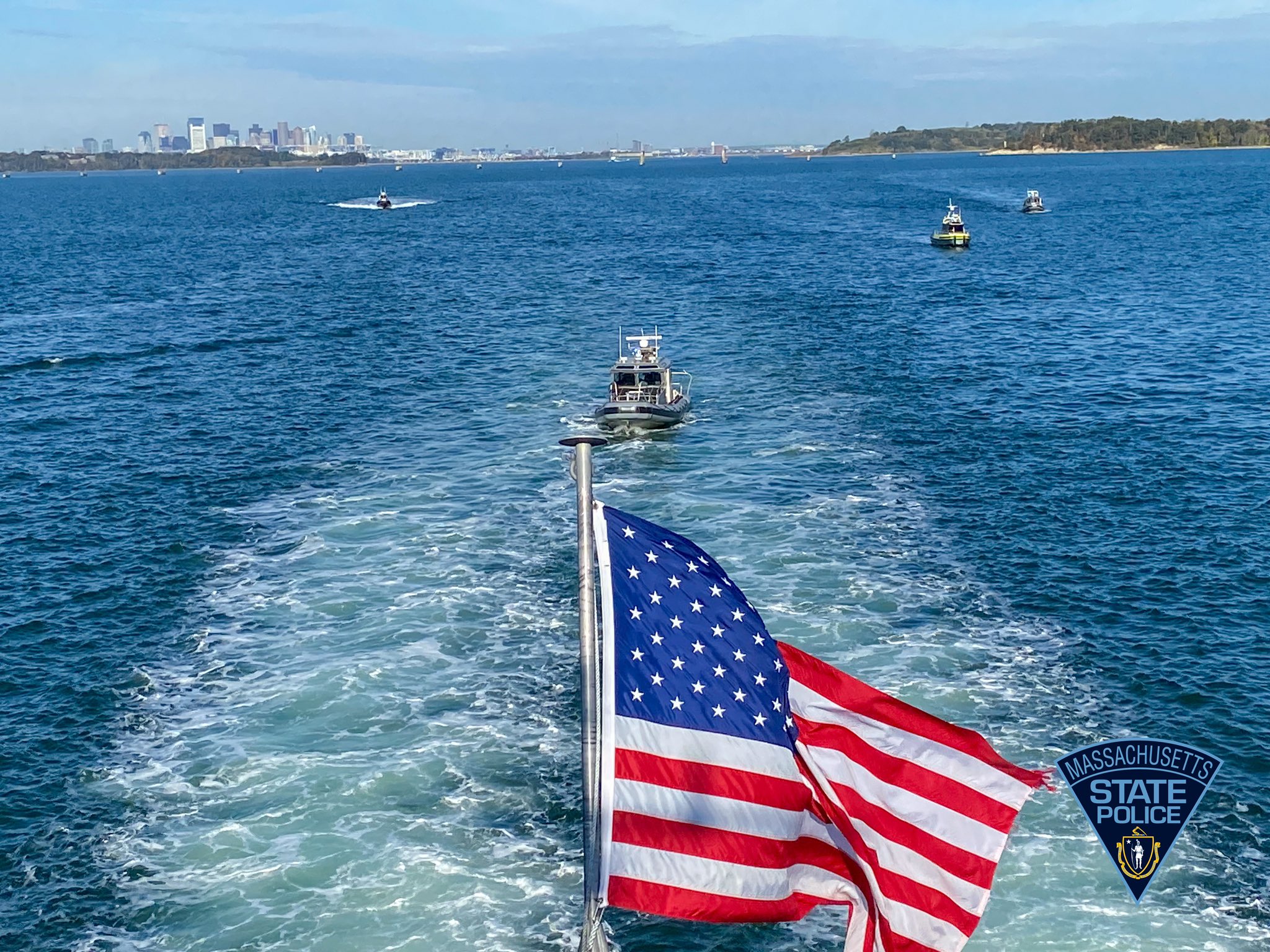 Several law enforcement boats underway in Boston Harbor.