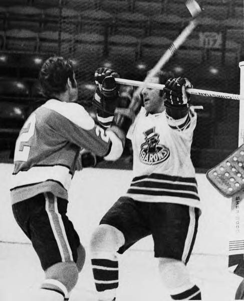 Cleveland Barons Grant Erickson gets stick up in time to stop stick wielded by Penguins' Duane Rupp. October 1, 1971. Photographer: Paul Tepley.