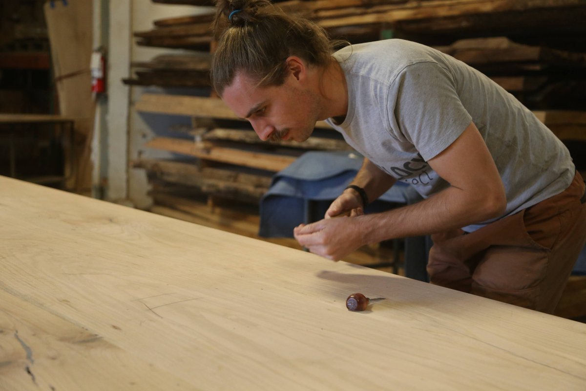 Travis_Gnehm's tweet photo. Members of our production team - Matt, Janelle, and Sam - doing some final detail work on this 30' x 7' conference table before it heads to our spray booth for finishing. https://t.co/kp0xa2OB1S
