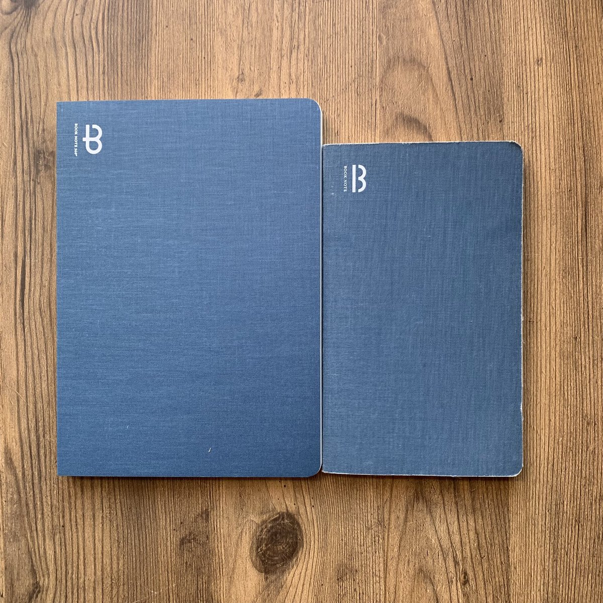 booknote_tokyo's tweet image. 今日は「デニムの日」。
弊社商品一番の定番BOOK NOTE のデニムブルーという色の物を新旧並べてみました。
右はカスタムカットした私物で旧ロゴVer.。
表紙はリネンクロスですが、色も経年変化の感じもデニムみたいでしょう？
　#booknote