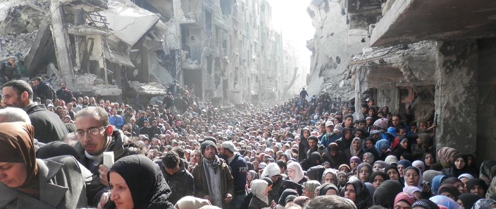1/ Here you can see hundreds of Palestinians queuing for food, but they're not in Gaza. They're in Yarmouk, Syria.