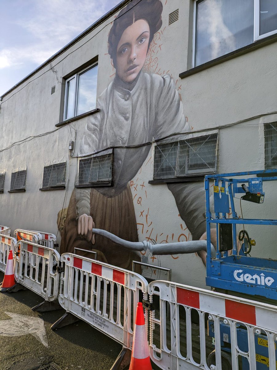 SupportLivingSt's tweet photo. A woman going places (on her bike)... Bold new mural of Josephine Cantwell, first woman elected to Kingstown Urban District Council 15 Jan 1920. Cantwell Lane (side of Mike'sBikes). Her family ran The Star and Garter Hotel in D2 (later @IrishTimes building) #livingstreets @dlrcc https://t.co/dViBCHMxdM