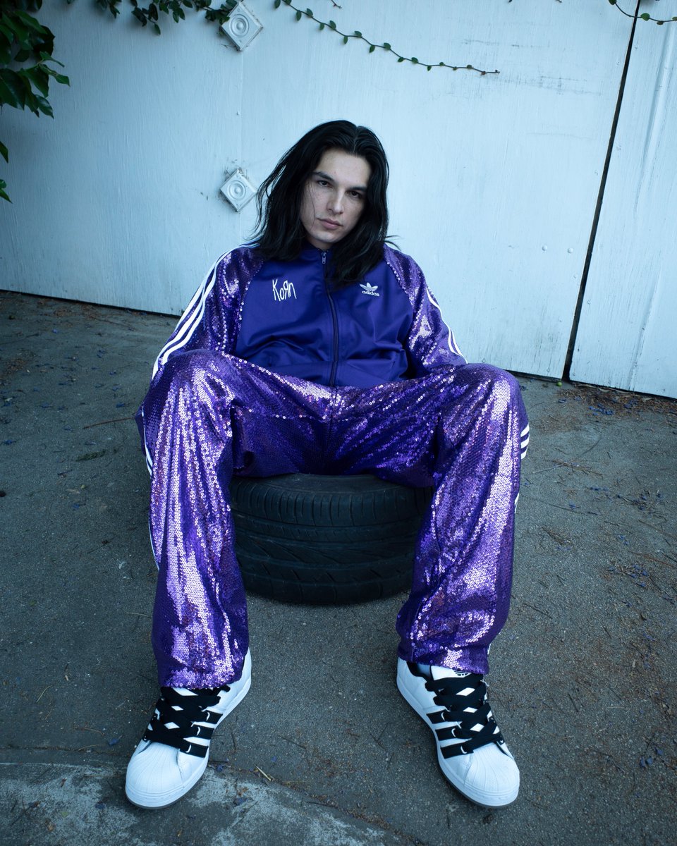 Korn's tweet image. The iconic purple sequin tracksuit, created by Jonathan Davis in 1996, is now available in its reimagined form - limited and exclusive to our official kornwebstore.com. Shop the full #KoRn x @adidasoriginals collection now.