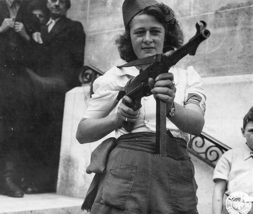 French Resistance fighter Simone Segouin, also know by her alias 'Nicole Minet', poses with a captured German MP 40 submachine gun, 1944. #History #WWII