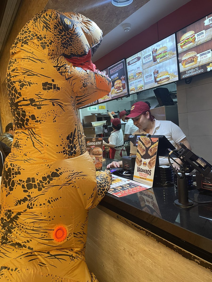 lcarochillon's tweet photo. Un dinosaurio comprando una hamburguesa con su tarjeta morí de risa haciendo la ful detrás de él 🫣 https://t.co/AuB8Cf8ihN