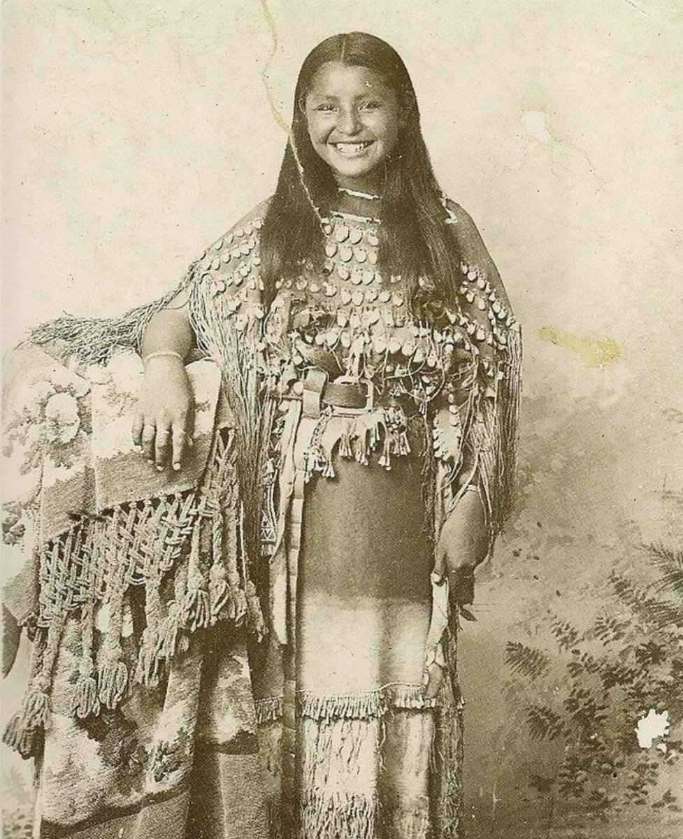 A Kiowa girl named O-o-be wears a three-hide dress decorated with elk teeth, Oklahoma, 1894. She was born and raised during the reservation period, which lasted from 1868 to 1906. The US had previously tried to assimilate her tribe by sending in Quakers and Christians as 'Indian…