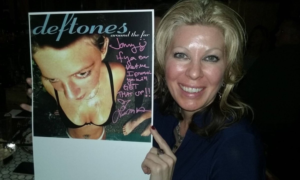 Lisa Hughes, better known as 'woman from the Deftones' Around the Fur album cover,' poses with signed photo of herself (2017)