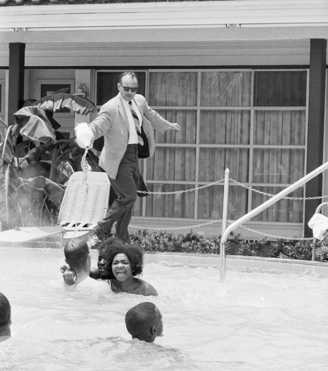 Motel manager James Brock pours Muriatic acid In the Monson Motor Lodge swimming pool, to get black swimmers out of the pool. June 18, 1964.