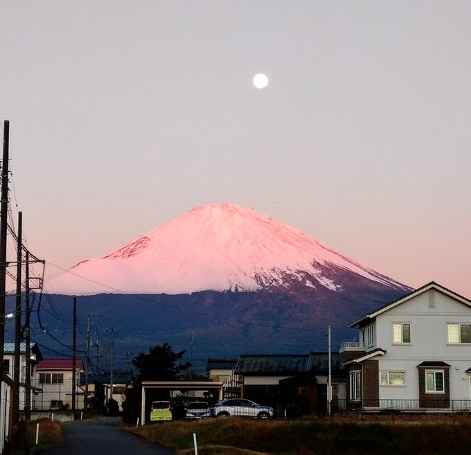 日の出に照らされて赤くなる富士山と沈みきってない満月