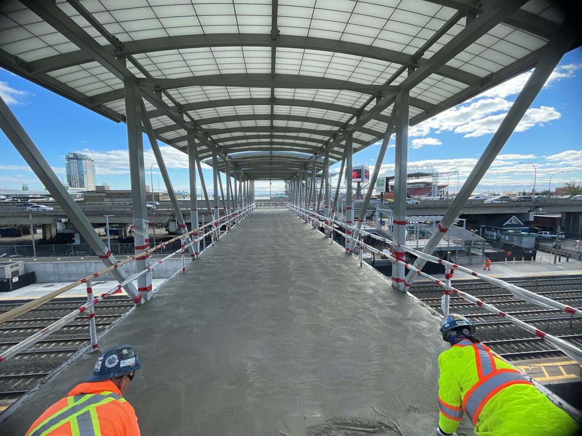 OntarioLine's tweet photo. POV: you're one of the first people to see the view from the temporary pedestrian bridge at Exhibition Station.👀🌉 

Roughly 50 cubic metres of concrete was poured this weekend and teams continue to complete tasks to get the bridge ready for use. https://t.co/R2wRQ4bBEy