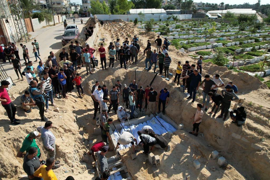 Timesofgaza's tweet photo. With death toll approaching 10,000, several graveyards in Gaza Strip fill up to their capacity and corpses are being collectively buried in mass graves wherever possible. https://t.co/i6GJ2sXPxu