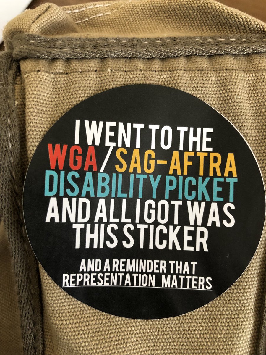 Accepted #SagAftraStrongChallenge Pic 1 by @elyhenry of #RickHowland in Sag-Aftra shirt and holding a sign for a character actor march Pic 2 the WGA and Sag-Aftra disability awareness sticker by @aannggeellll