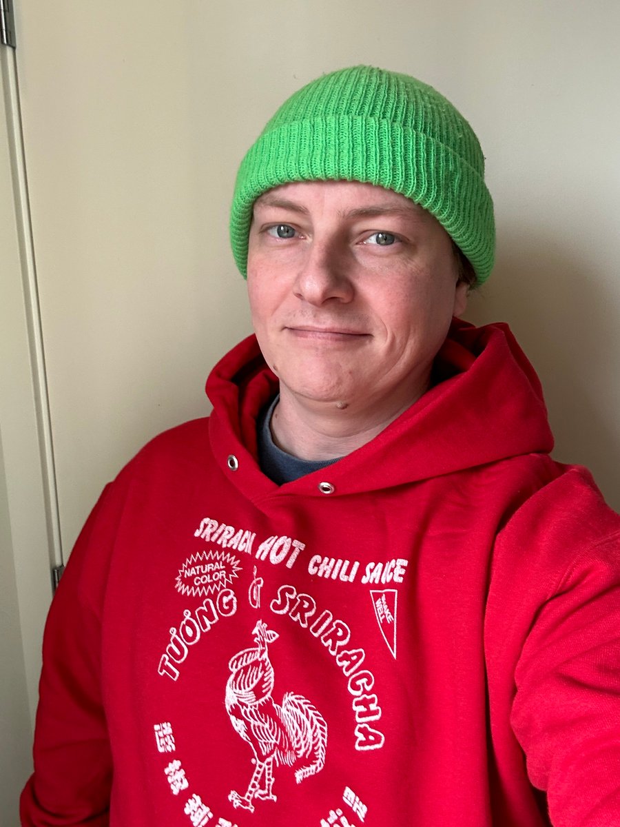 Photo of me in a Sriracha hoodie and Green Beanie.