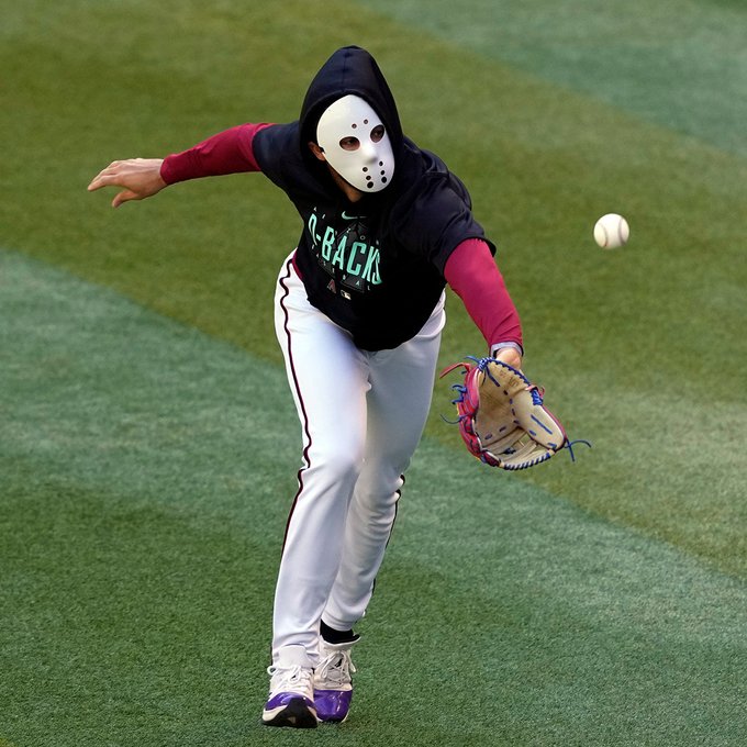 Lourdes Gurriel Jr. chasing a fly ball during warmups before Game 4 of the World Series while wearing a mask of the character Jason Voorhees from the Friday the 13th movies.