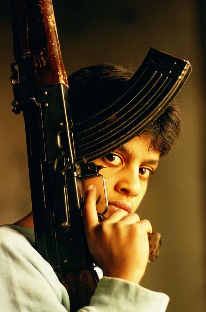 طفل فلسطيني يحمل رشاش كلاشينكوف في مخيم برج البراجنة للاجئين الفلسطينيين في لبنان - يونيو 1997. 

📷 توم ستودارت