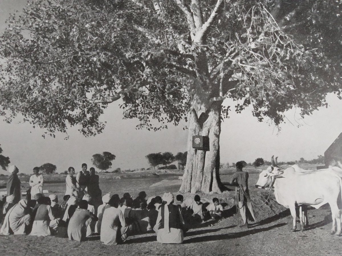 1950s :: Villagers Listening to News On All India Radio.

Radio Set Is Hanging On a Tree