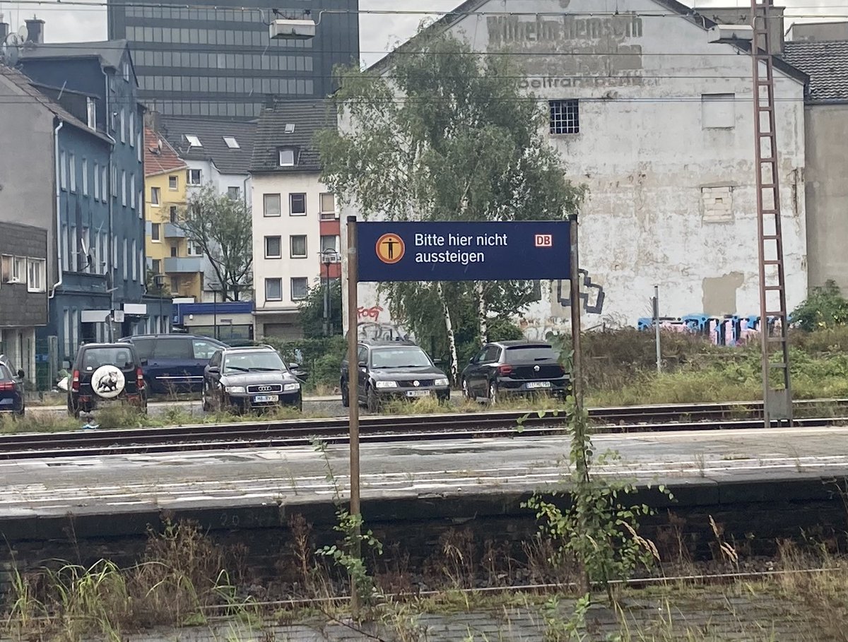 Ein schild auf einem eher verwahrlosten bahnsteig auf dem steht: Bitte hier nicht aussteigen.