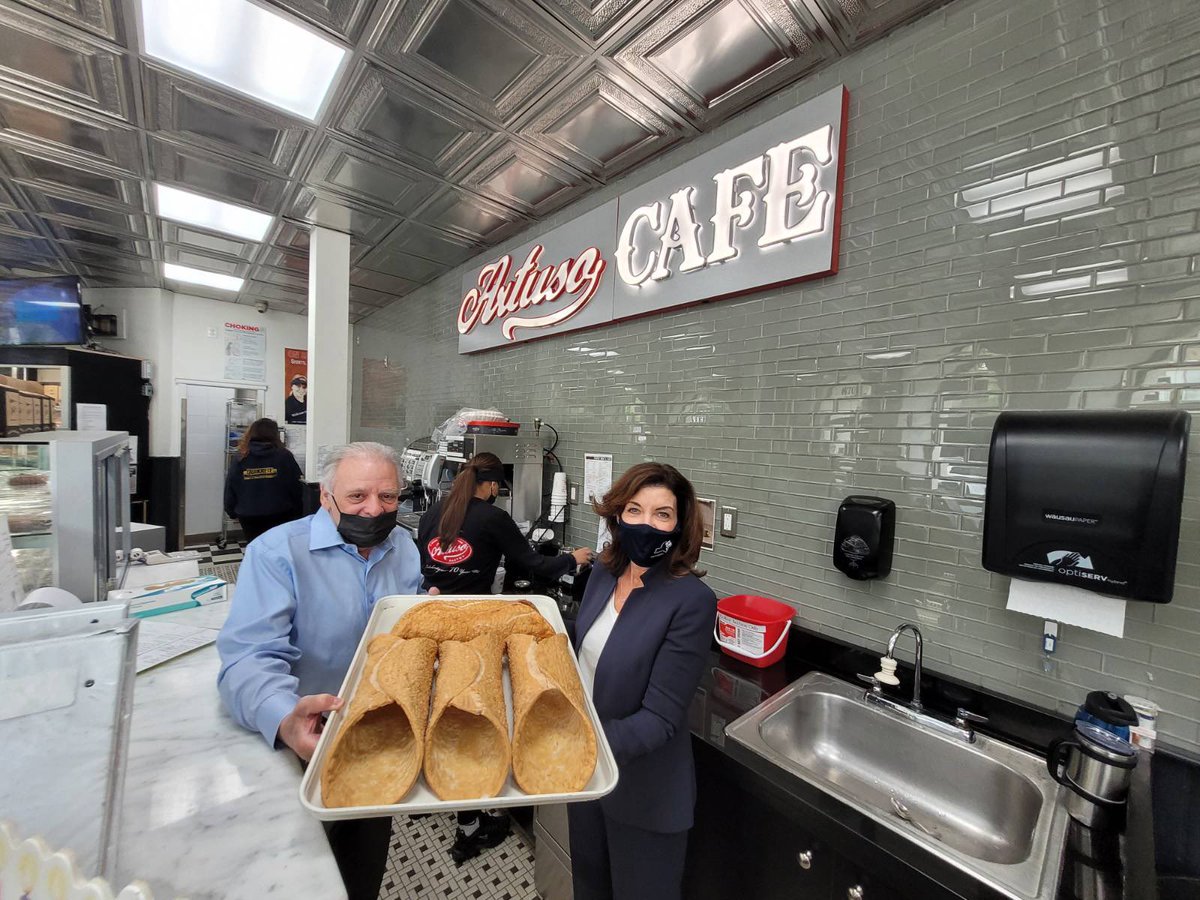 Governor Hochul at Artuso Bakery holding x-large cannoli shell