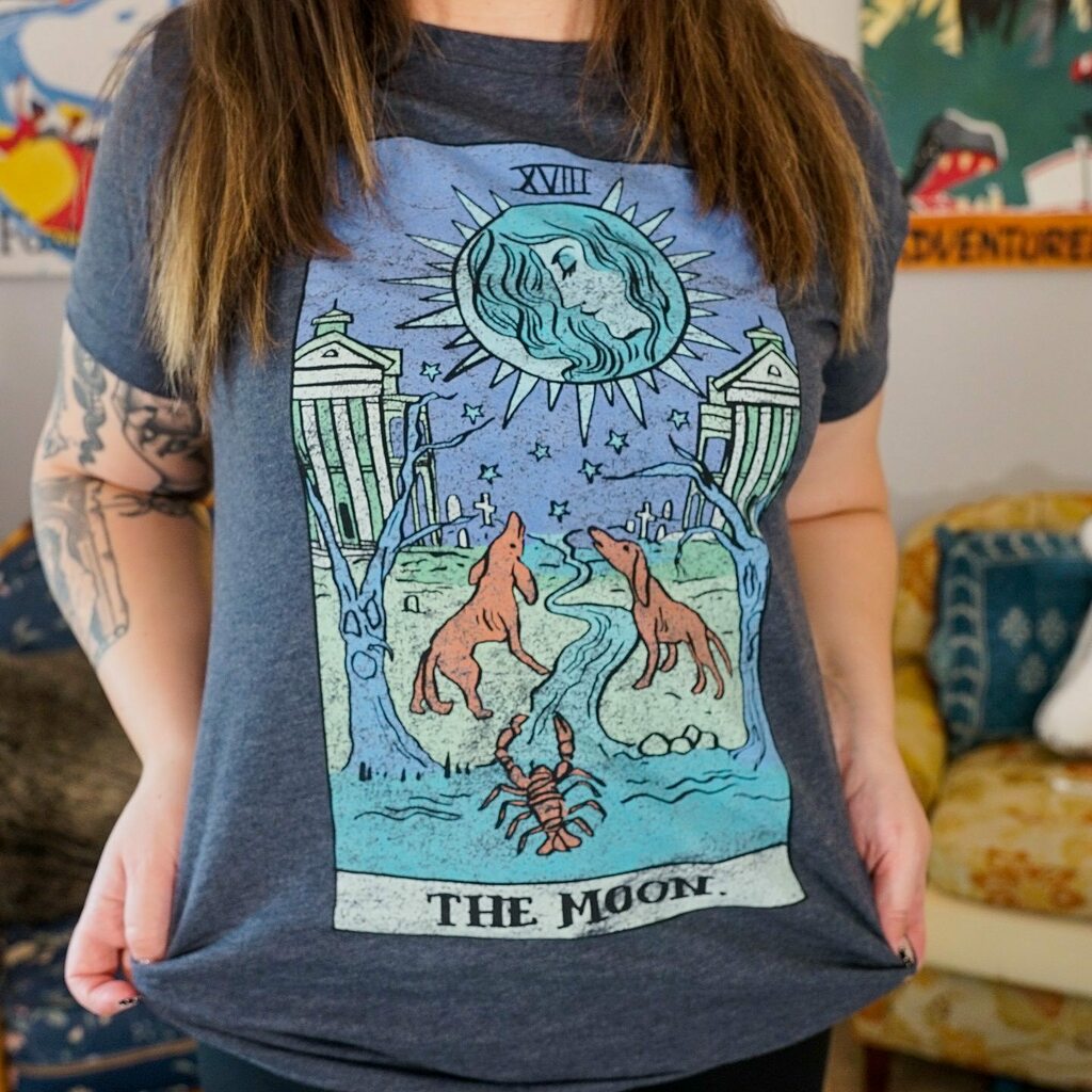 LostWeekenders's tweet photo. MORE NEW DESIGNS 🎃The Haunted Mansion moon tarot to the Small World sun tarot. Isn’t she just perfect. Drops with the rest of our 2021 Halloween collection tomorrow AM. 
🎃🎃🎃
#disneysmallshop #disneyshirts #disneyhalloween #disneycreepy #disneytarot https://t.co/lpxDuuhqJN https://t.co/ogFmLAmUrF