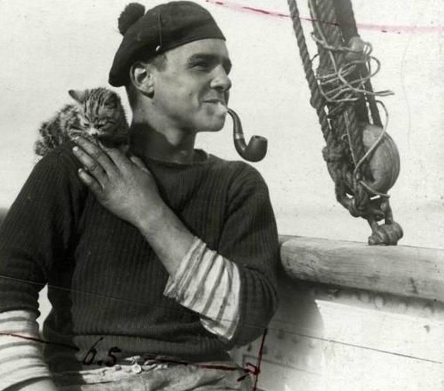 Dutch sailor with pipe and the ship's cat aboard lightship (sort of floating lighthouse) Noord-Hinder. North Sea, 1912.