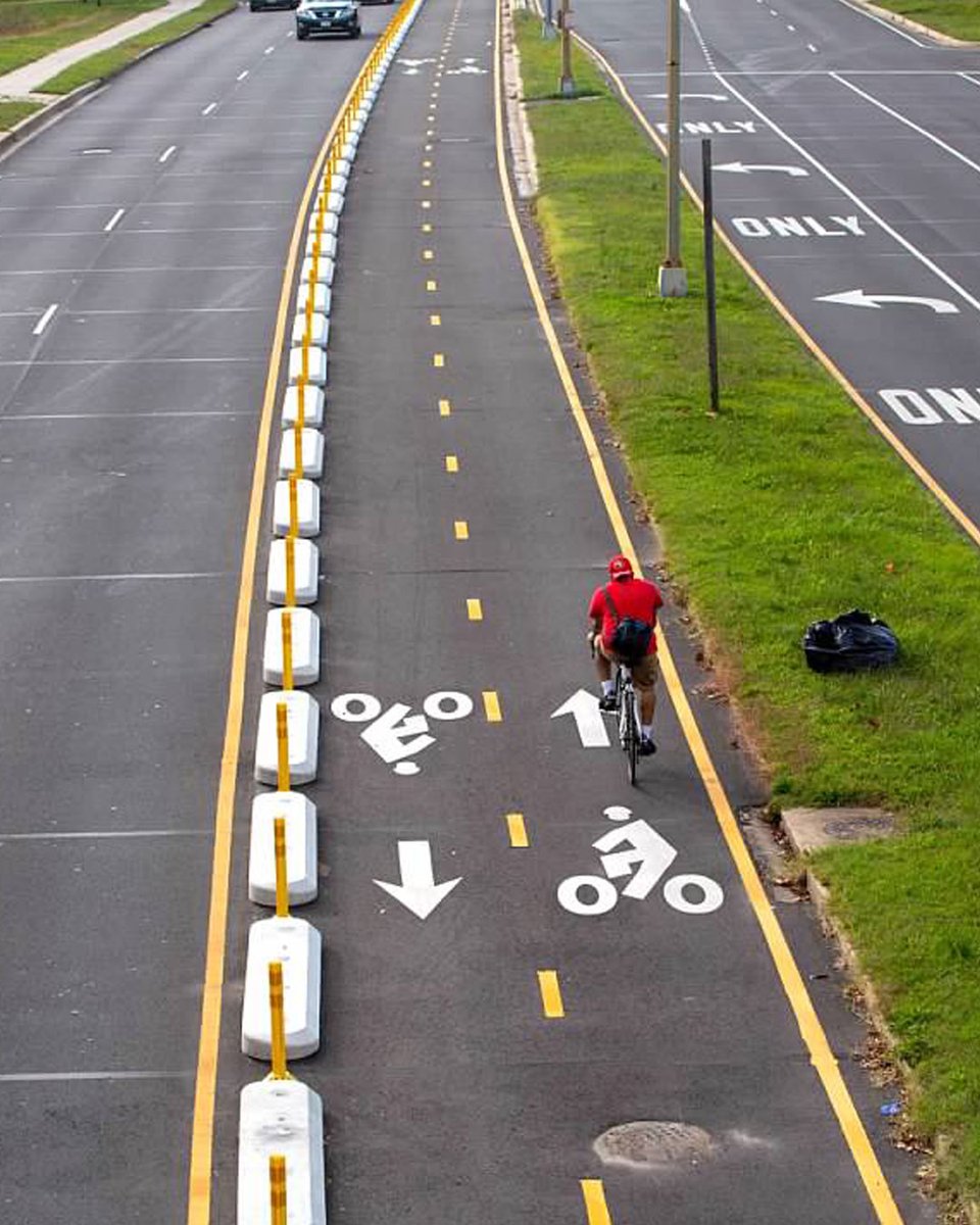 DDOTDC's tweet photo. A protected bike lane is a space for #bicycle/ #scooter use separated from main travel lanes by a physical barrier. These lanes help folks share the road safely and offer the additional benefit of traffic calming, which discourages speeding on the road ๐ฒ #BuiltForSlow https://t.co/4fDLcCtmv1