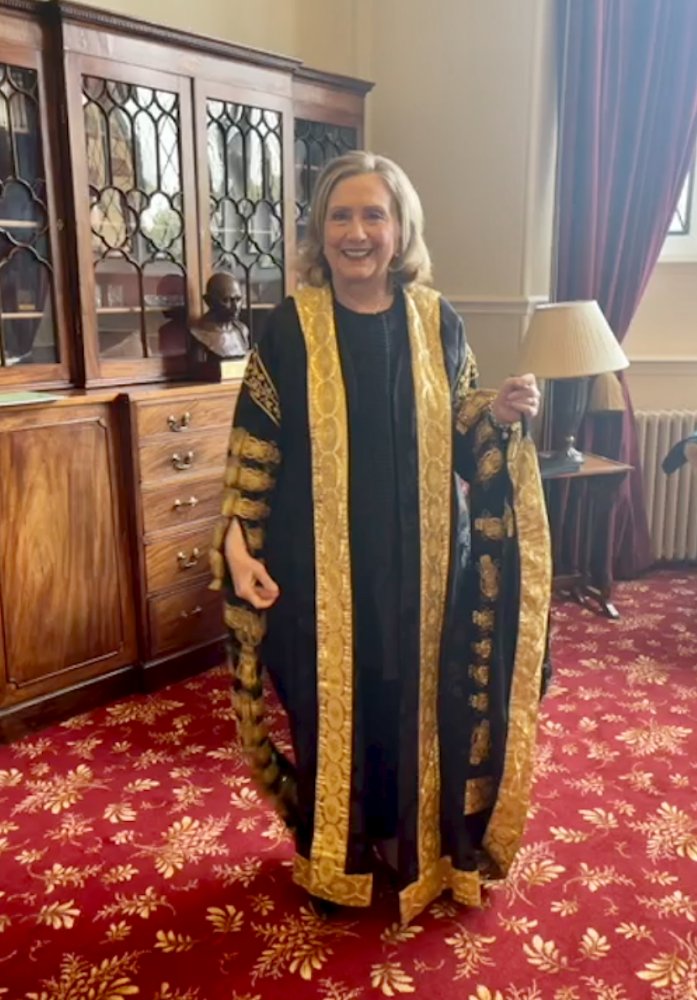 HillaryClinton's tweet photo. Trying on my new chancellor's robes for size. They fit! 

So honored to be officially installed today as the first female chancellor of @qubelfast—doubtless the first of many. #LoveQUB https://t.co/7GhBzdSqE0