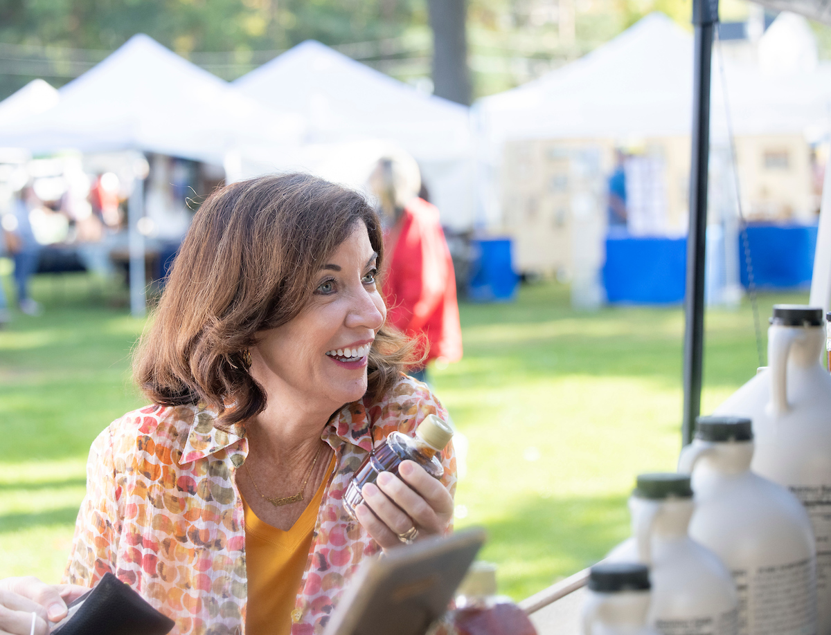 Governor Hochul holds a bottle of maple syrup