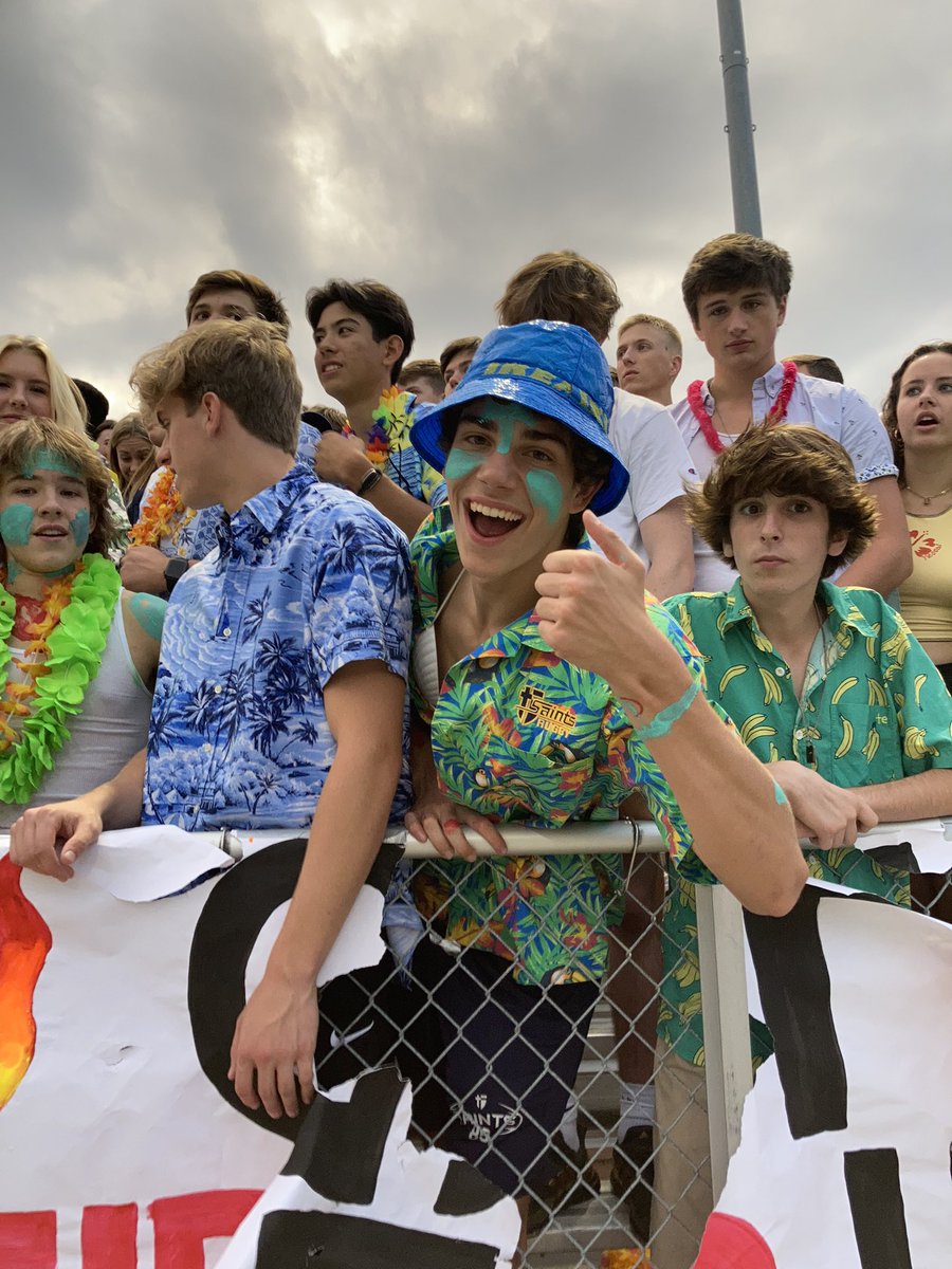 stasaintsrugby's tweet photo. Senior rugby players lined the front row cheering section of the homecoming football game last night! Bringing the Hawaiian vibes, Saints Rugby players could be seen leading cheers & showing off their island fashion! @stasaints #homecoming2021 #islandstyle #Cheeringsection https://t.co/Fkk4wmCPYr