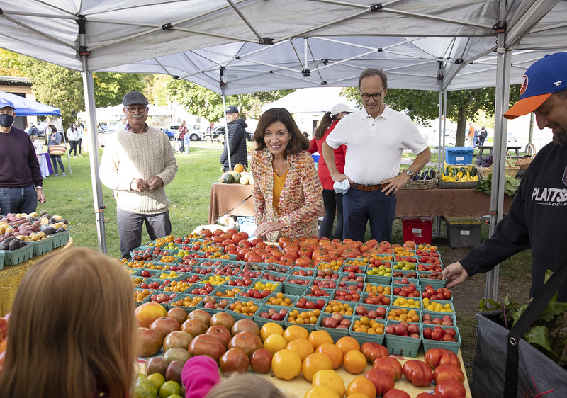 Governor Hochul and her husband look at tomatoes at Saranac Lake Farmers Market