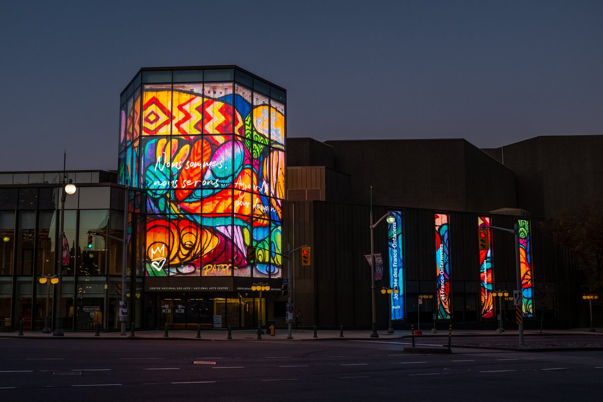 CNAduCanada's tweet photo. Francophones de l’Ontario, l’équipe du CNA vous souhaite un bon #25septembre! Pour souligner la journée des francos de l’Ontario, nous avons le plaisir de mettre de nouveau en vedette sur la Lanterne Kipnes l’artiste muraliste @MichellMique. #OnFr #FrCan ➡️https://t.co/O3A0eKDXif https://t.co/VguADErmaF