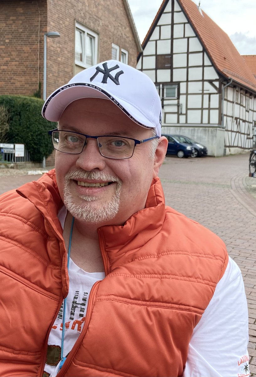 Ein Foto von Olaf Engel im Rollstuhl sitzend auf einem Platz in Wunstorf zwischen Backstein- und Fachwerk-Häusern