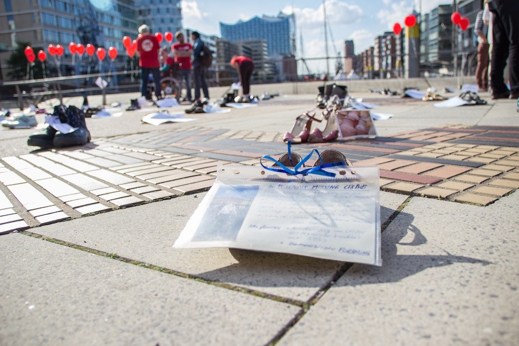 Schuh mit (nicht lesbarer Botschaft), im Hintergrund stehen weitere Schuhe.