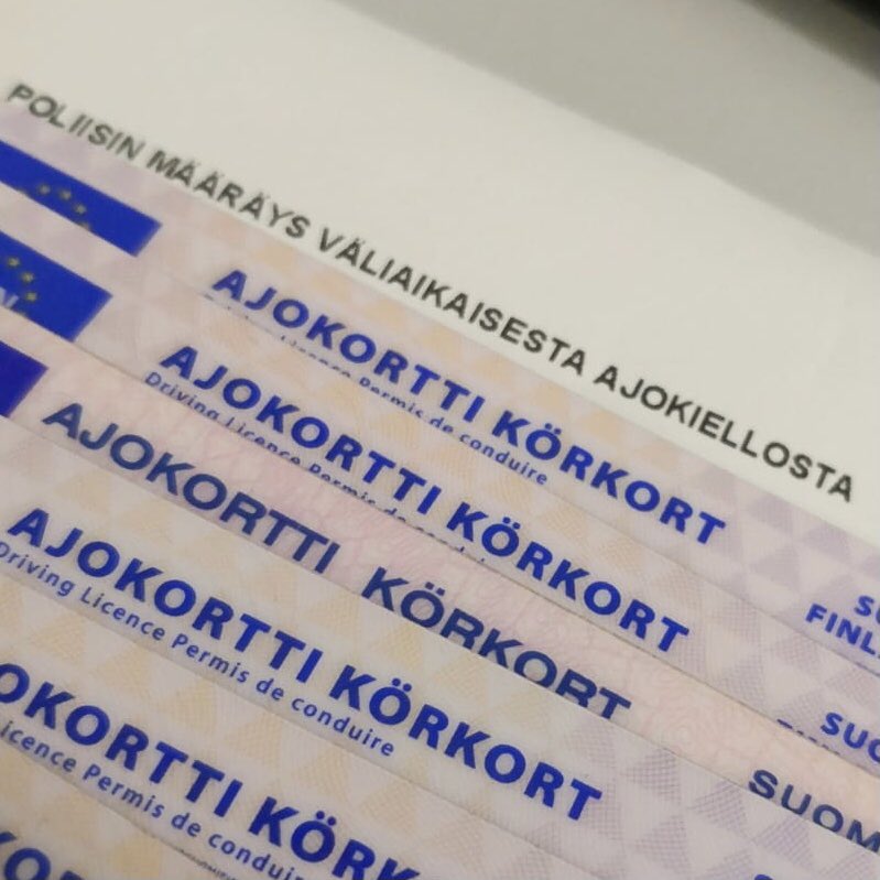 Ajokortteja aseteltuna lähekkäin jonoon pöydälle.