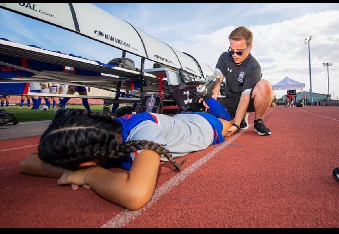 UD_ATEP's tweet photo. Matthew Cecchett (Class of 2021) works to stretch out one of his Houston Baptist University ⁦@HBUHuskies⁩  women’s soccer players prior to a recent game.  Continued good luck and success in your ATC role and graduate studies there in Houston, TX! https://t.co/P8wSCmo2J2