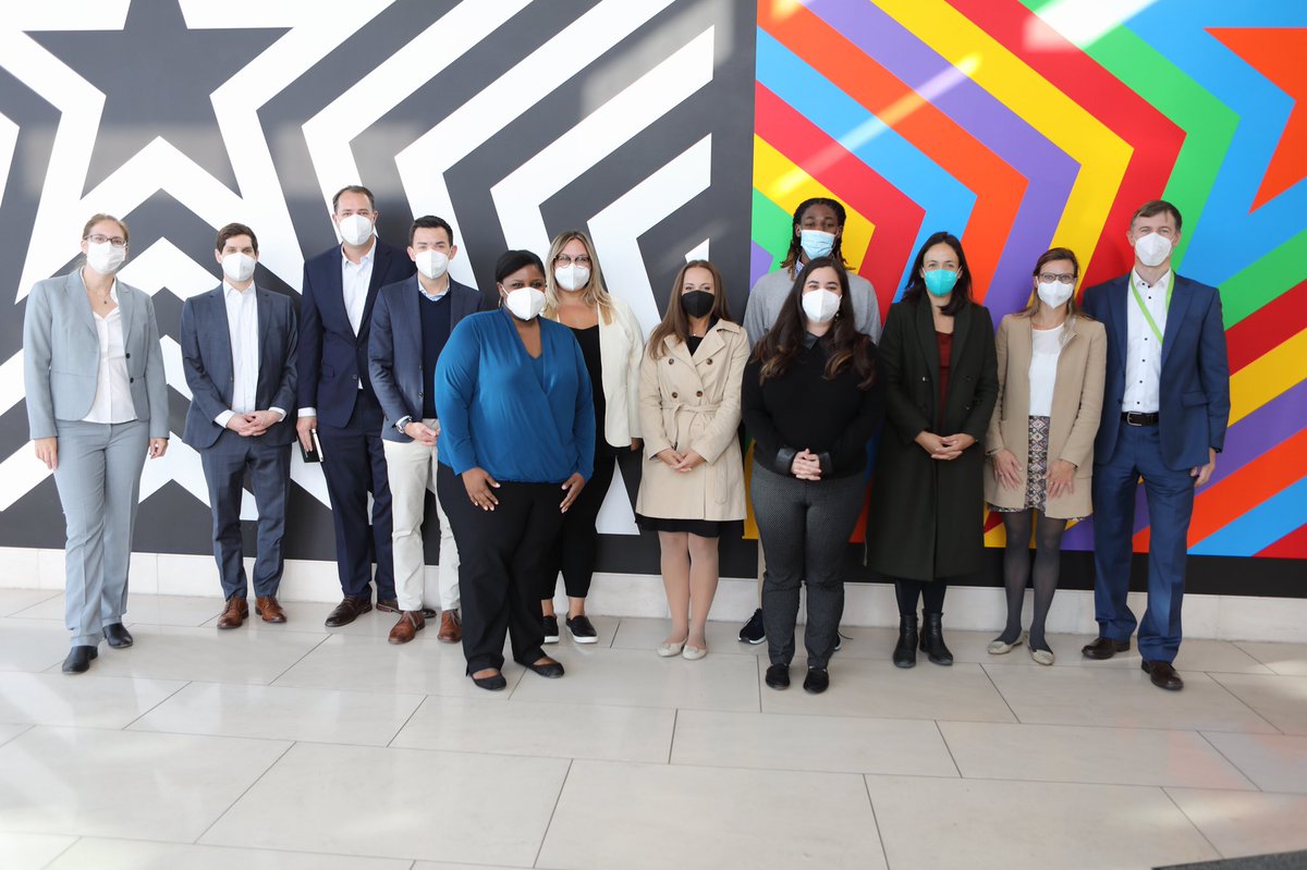Group of people standing in front of five-pointed stars mural