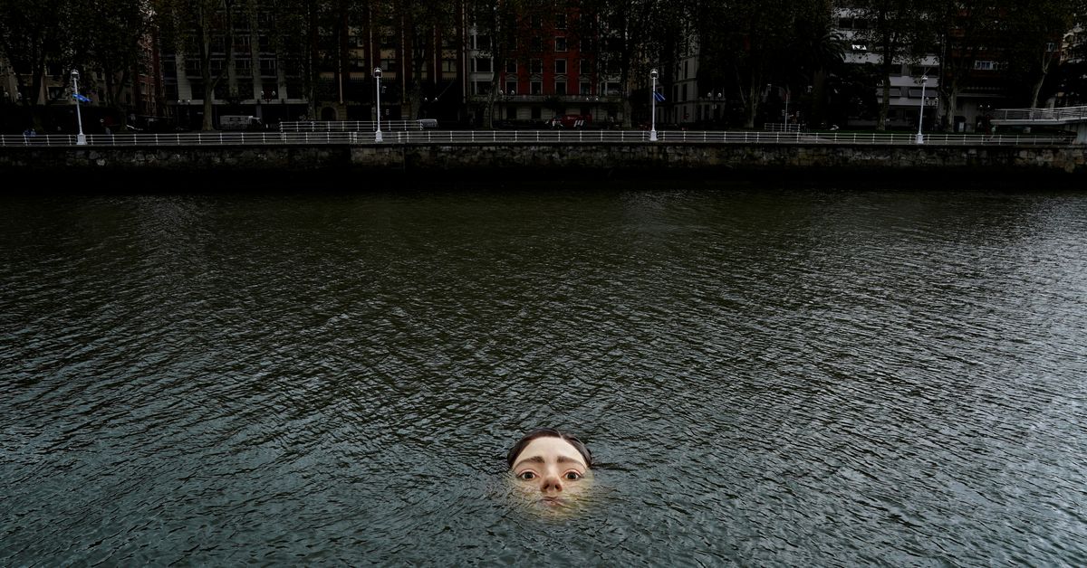 Reuters's tweet photo. Drowning girl statue causes a stir in Bilbao https://t.co/36RvcN52jY https://t.co/r3IhMVBtw2