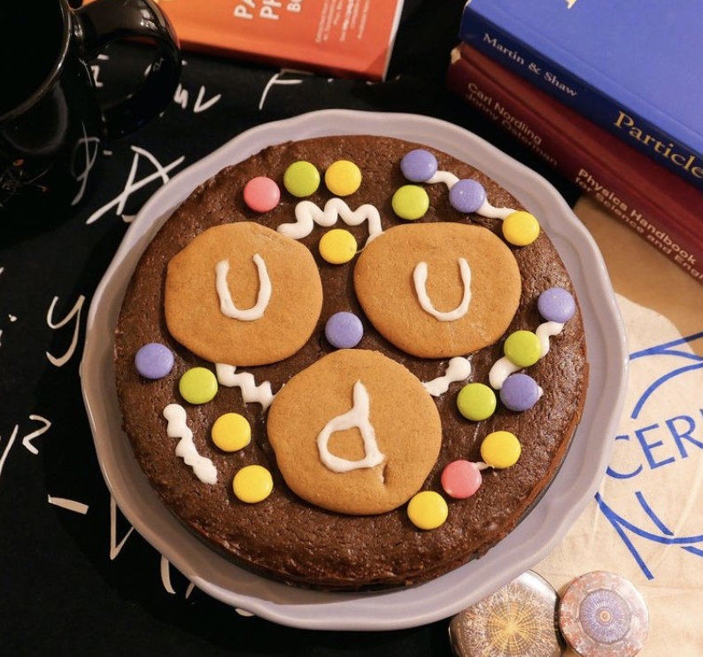 CERN's tweet photo. HAPPY BIRTHDAY CERN! 🎂🥳 

What better than a proton cake for CERN’s 67th birthday! #PhotoOfTheWeek

This cake from the @PhysicsCakes includes gingerbread cookies for the two up quarks and one down quark plus colourful sea quarks &amp; gluon icing.😋

🔗https://t.co/Wfb84igQen https://t.co/7ByPdxtkqm