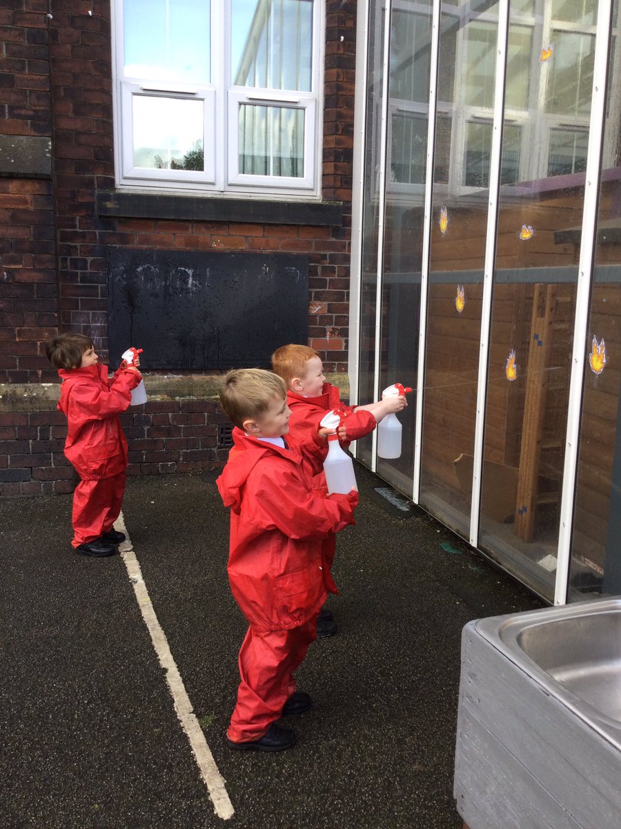 ReceptionClass2's tweet photo. We are being firefighters this morning with our strawberry suits on to keep us dry. This helps us to develop our fine motor skills, which will help us to write! #EYFS #outdoorlearning #finemotordevelopment https://t.co/1v6By13pk7