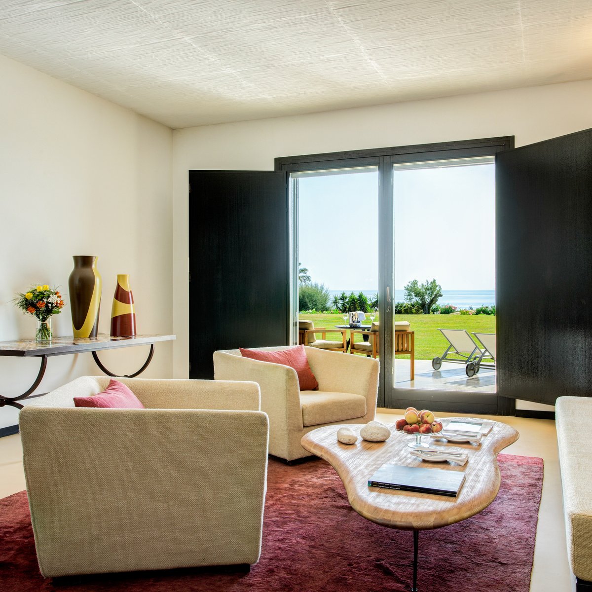 Sunlight floods in from the Classic Suite's double terrace doors, highlighting the open floor plan's airy charm. #RoccoForteHotels #RoccoForte #Sicily #VerduraResort