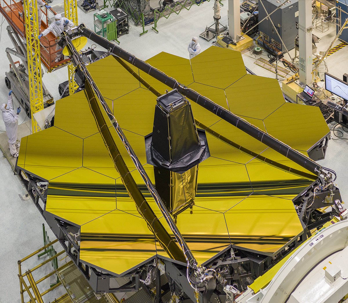 The golden mirror lies flat after assembly at NASA Goddard. The secondary mirror boom is folded.