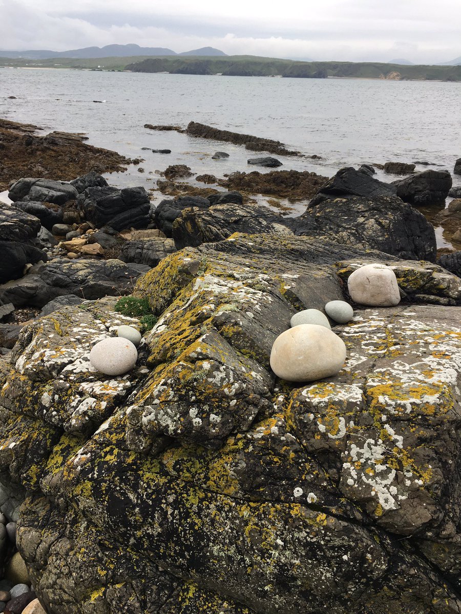 MMaryMcKenna's tweet photo. I loved these beach cobbles sitting on rocks today - uncertain if they were placed there by the Atlantic Ocean or by human hand … or perhaps even by the little people … #FiveFingerStrand #Donegal https://t.co/hvMSXlfnYA