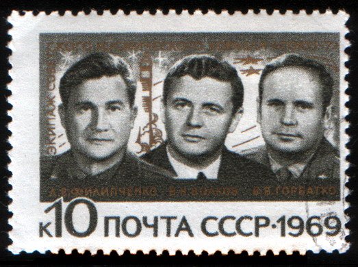 Stamp with three men on it