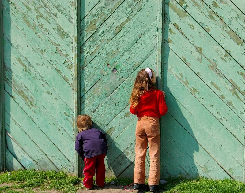 девушка у двери. девушка заглядывает за дверь. мама с ребенком в деревне. девушка через забор. любопытный человек.