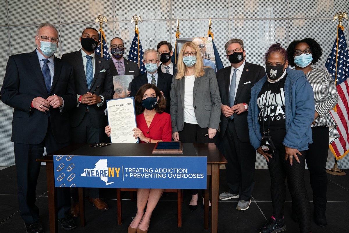 Photo of bill signing ceremony during which Governor Kathy Hochul signed various legislation to combat the opioid crisis. Advocates and bill sponsors behind the Governor.