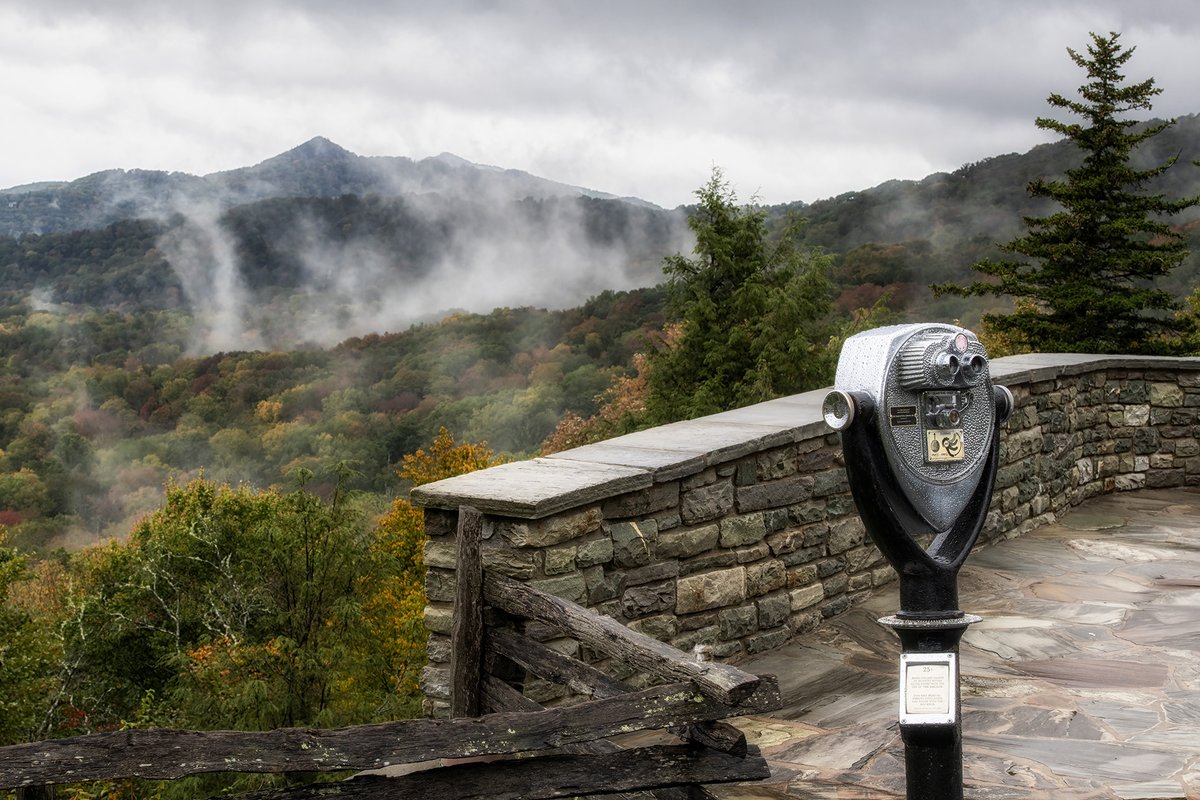 GrandfatherMtn's tweet photo. You don't necessarily need a viewfinder to see #fallcolor spreading along #GrandfatherMtn's slopes into the surrounding #mountains below, but it certainly couldn't hurt. Here, low-laying clouds glide over the reds, golds and greens of early #autumn. 

Photo by Skip Sickler | GMSF https://t.co/fsMT5MKtwm