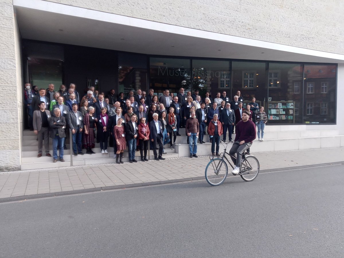 Gruppenbild der Teilnehmer*innen. Fahrrad fährt vor der Gruppe lamg