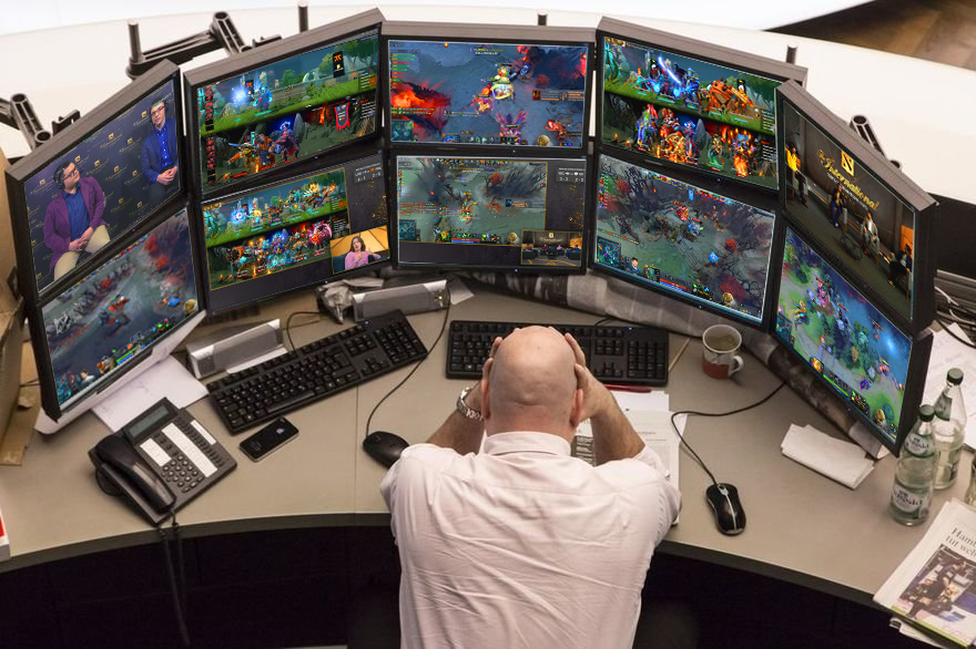 a man surrounded by monitors trying to watch TI10 groupstage